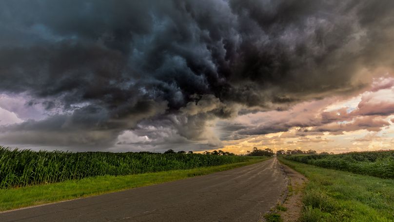 A storm building over a country road